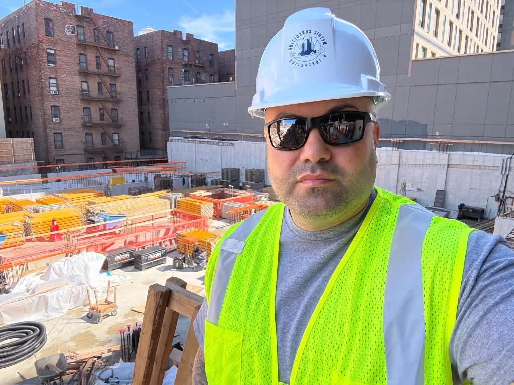 Metric inspector in a branded hard hat on a New York City construction site