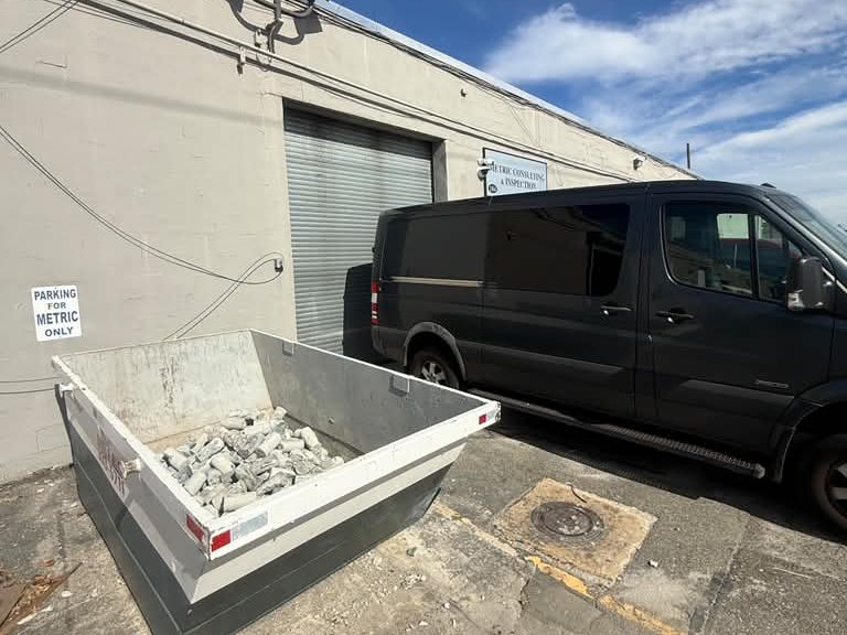 Metric van parked at the laboratory loading door next to a container of tested concrete
